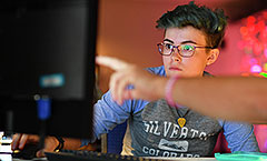 Student looking at computer with lights overhead