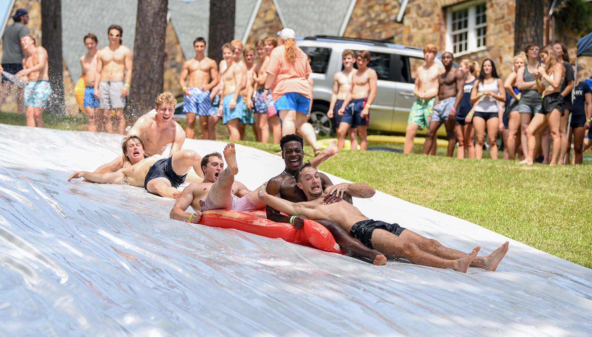 Group of guys laughing on a slip n slide