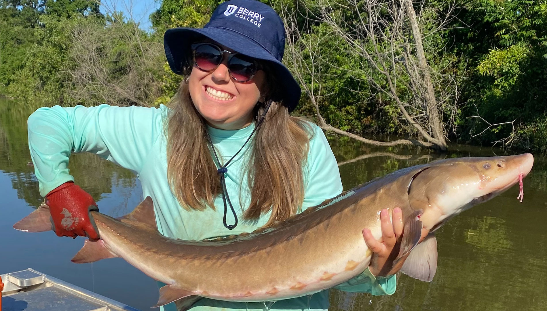 Student holding sturgeon she is studying